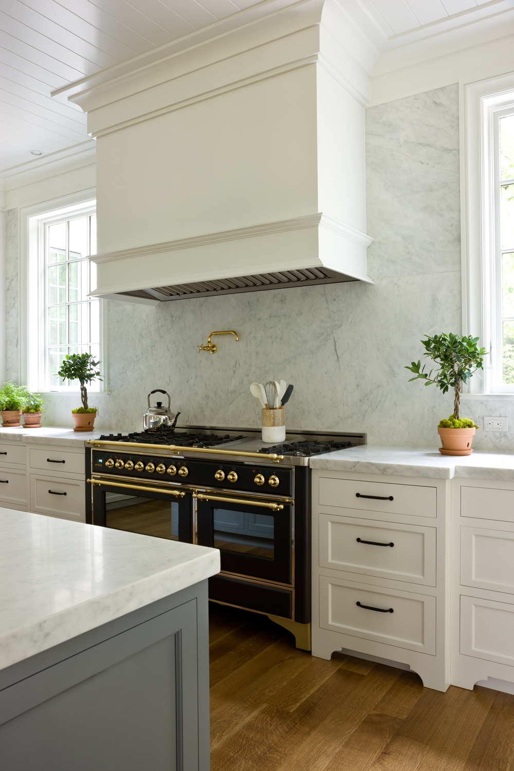 white kitchen with black italian range and marble backsplash